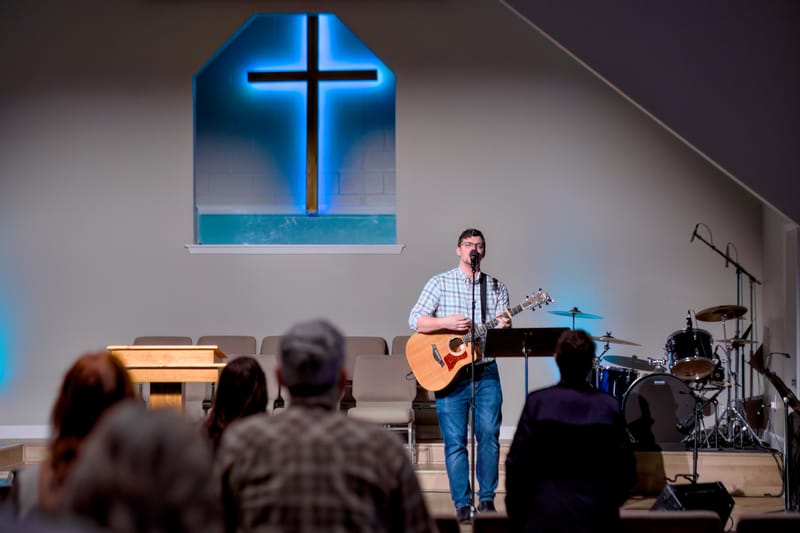 A musician playing keyboard with the worship team during a Sunday service.